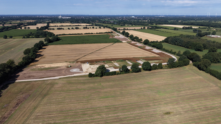 Luftaufnahme der Baustelle des Trianel Windparks Tasdorf: Felder und Knicks im Landkreis Plön, in der Mitte ein vorbereiteter Anlagenstandort mit Zufahrtsweg